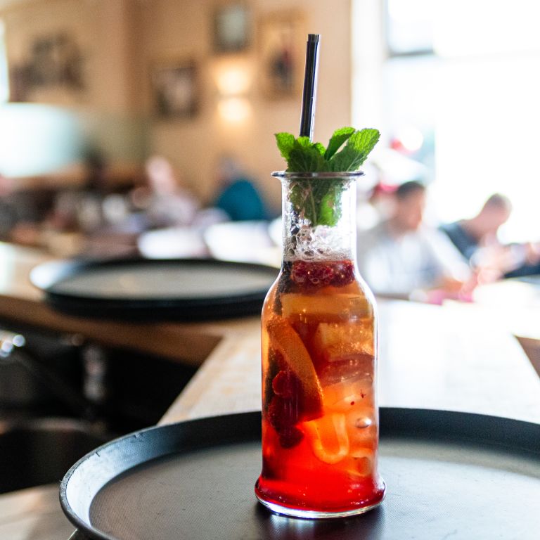 Ein rotes, fruchtiges Getränk mit Eis und frischer Minze in einer Glaskaraffe