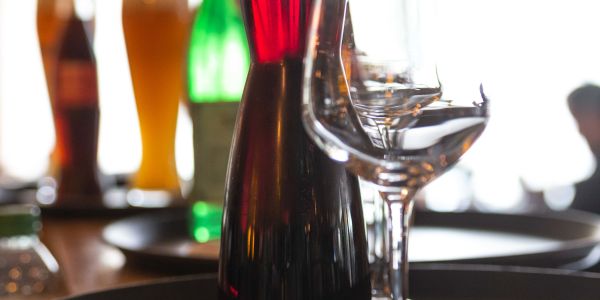 Karaffe mit tiefrotem Wein neben Weinglas bereit zum Servieren
