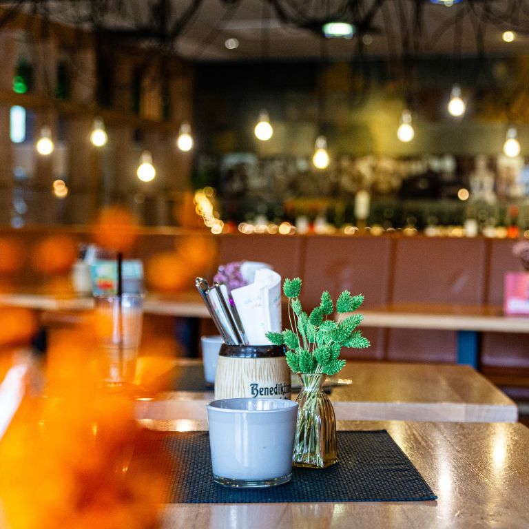 Restaurant-Tischdeko vor stimmungsvollem Hintergrund.