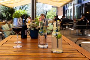 Zwei große Glaskaraffen mit erfrischender, eisgekühlter Limonade – verfeinert mit Minze, Limette und Zitronenstückchen – auf dem Terrassentisch.