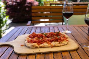 Bruschetta, reich belegt mit frischen Tomatenwürfeln und Kräutern- Auf einem Holzbrett serviert.
