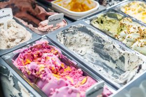 Eisvitrine mit verschiedenen Eissorten in Metallbehältern.
