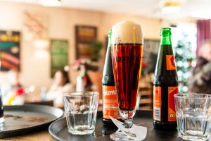 Frisch gezapftes dunkles Weizenbier im Glas auf einem Serviertablett.
