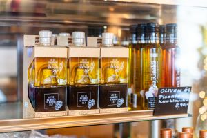 Verkaufsregal mit Geschenksets aus Olivenöl und Balsamico sowie einzelnen Ölflaschen.

